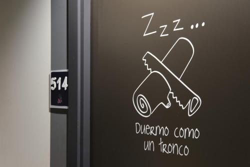 a sign on a door with a painting of a plunger at Ibis Budget Bilbao City in Bilbao