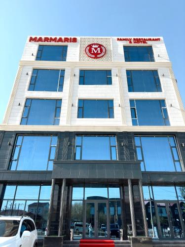 a building with a sign on the front of it at Marmaris Hotel in Nukus