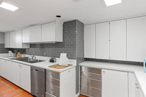 eine Küche mit weißen Schränken und einer Spüle in der Unterkunft Ocean Drive Oasis w Hot Tub Awaits in Corpus Christi