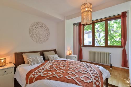 ein Schlafzimmer mit einem großen Bett und einem Fenster in der Unterkunft Les appartements du Manoir des Sens in Thannenkirch