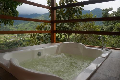 a bath tub filled with water in front of a window at Terrabambu Lodge in Mindo