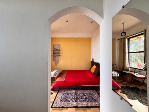 a bedroom with a red bed with a red blanket at The Hostel Stories Dharamkot - Mcleodganj in McLeod Ganj