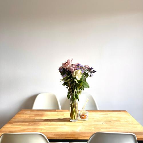 eine Blumenvase auf einem Holztisch in der Unterkunft Shiny apartment - Direct line to Olympic Village in Clichy