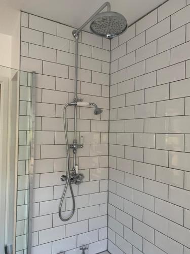 La salle de bains est pourvue d'une douche avec du carrelage blanc. dans l'établissement Rose Cottage, à Lustleigh