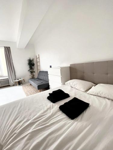 a large white bed with two black towels on it at Studio with wifi at Bruxelles in Brussels