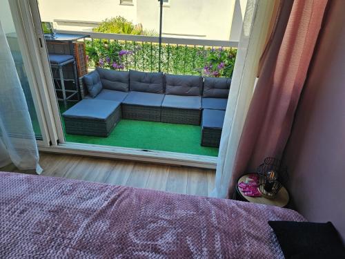 un salon avec un canapé sur un balcon dans l'établissement Naturiste Soleil New, au Cap d'Agde