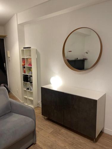 un salon avec un canapé et un miroir dans l'établissement Cosy Studio 16m2, à Lyon
