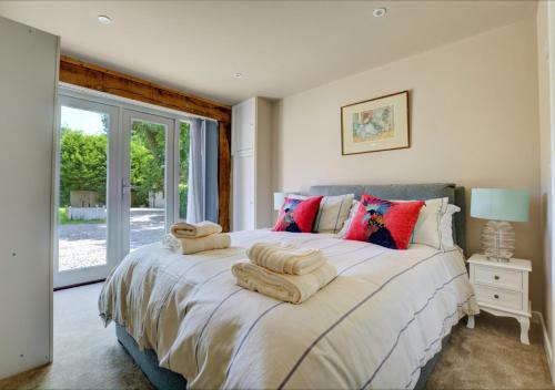 a bedroom with a large bed with towels on it at Primrose Cottages in Roughton