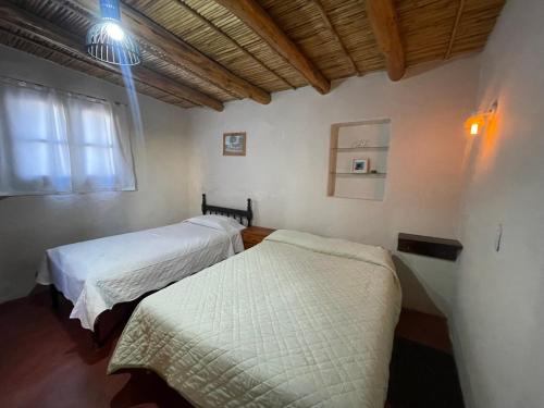 una habitación con dos camas y una ventana en Bello Atardecer, en Tilcara