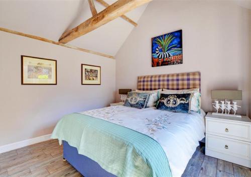 Hawthorne and Rainbow Cottage في Roughton: غرفة نوم بسرير في غرفة