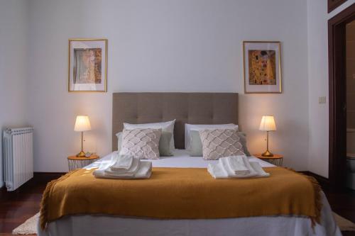um quarto com uma cama grande e 2 candeeiros em Cosy Historical House in Lamego - Quinta do Cabo em Lamego