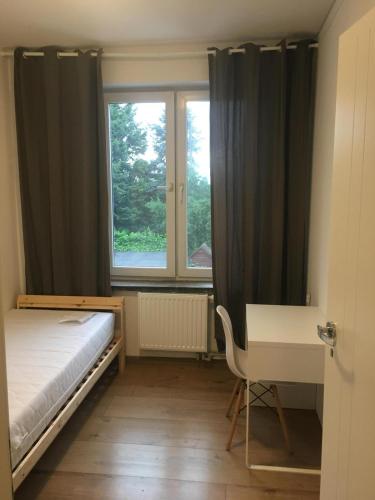 a bedroom with a bed and a desk and a window at Hallera Wroclaw in Wrocław