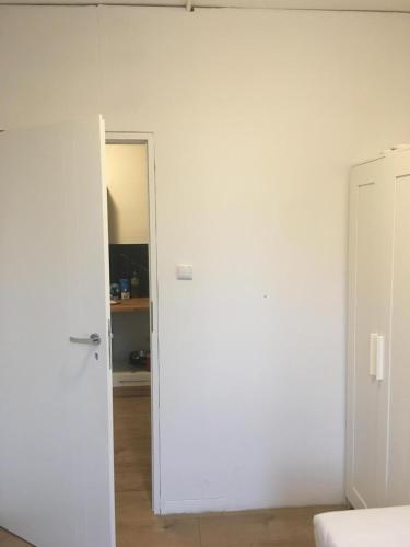 Zimmer mit einer weißen Wand und einer Tür in der Unterkunft Hallera Wroclaw in Breslau