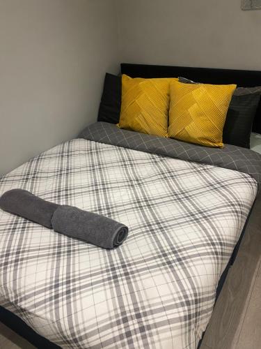 Cosy Citrine Suite - في لندن: سرير مع بطانيه ومخده صفراء