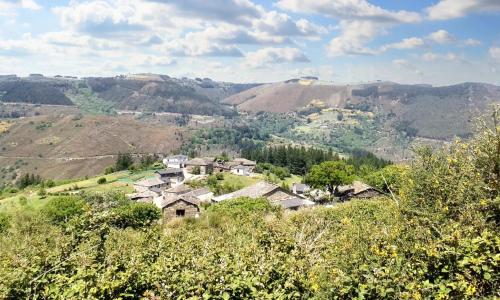 wioska na wzgórzu z górami w tle w obiekcie 2 bedrooms house with furnished garden and wifi at Grandas de Salime w mieście Grandas de Salime