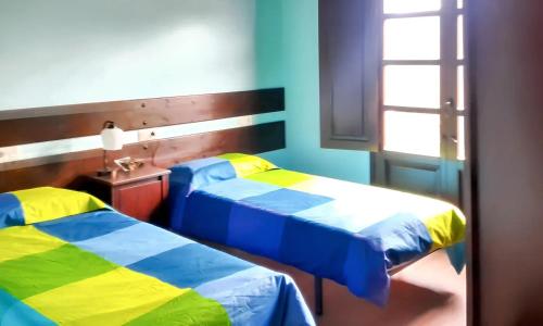 dwa łóżka siedzące obok siebie w pokoju w obiekcie 2 bedrooms house with furnished garden and wifi at Grandas de Salime w mieście Grandas de Salime