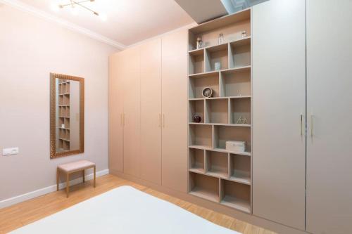 1 dormitorio con armarios blancos y espejo en New apartment in Vake for rent en Tiflis