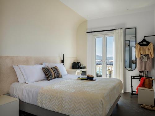 a bedroom with a bed and a large window at Yalos Hotel Sunset view Mykonos town private rooms in Mýkonos City