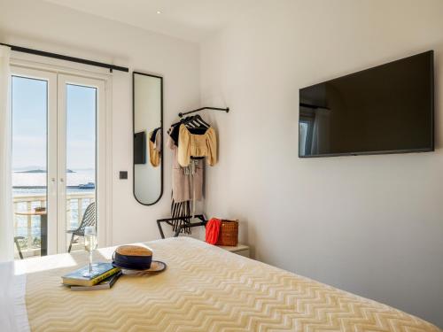 a bedroom with a bed with a flat screen tv at Yalos Hotel Sunset view Mykonos town private rooms in Mýkonos City