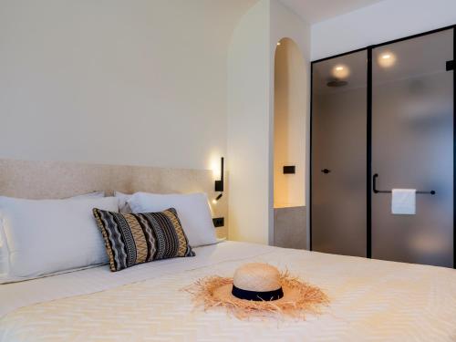 a hat sitting on top of a bed at Yalos Hotel Sunset view Mykonos town private rooms in Mýkonos City