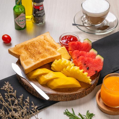 a plate of toast and fruit and a cup of coffee at La Vista Patong Hotel in Patong Beach