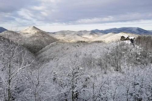 two people sitting on top of a mountain in the snow at Glimpse of Heaven in Sevierville