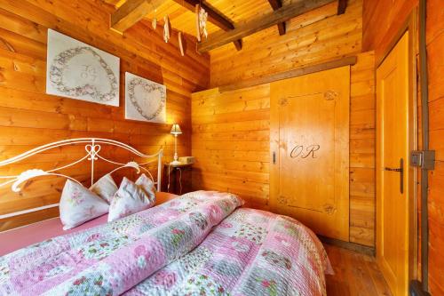 ein Schlafzimmer mit einem Bett in einer Holzhütte in der Unterkunft Orserose Chalet 6 I Scarpet in Forno di Zoldo