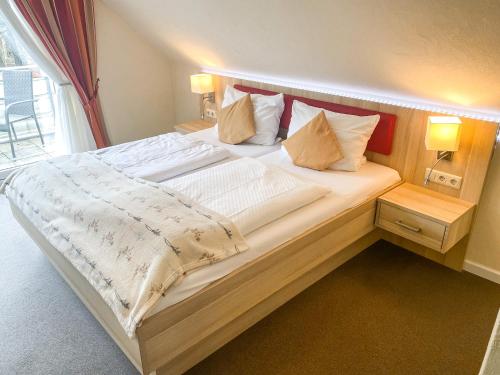 a large bed in a room with a window at Hotel Garni Silvana in Sankt Peter-Ording