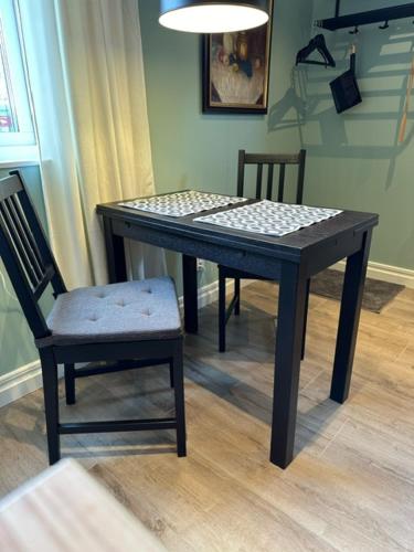 諾爾泰利耶的住宿－Dalkärret，一张带两把椅子的黑桌、一张桌子和一张桌子以及一把椅子