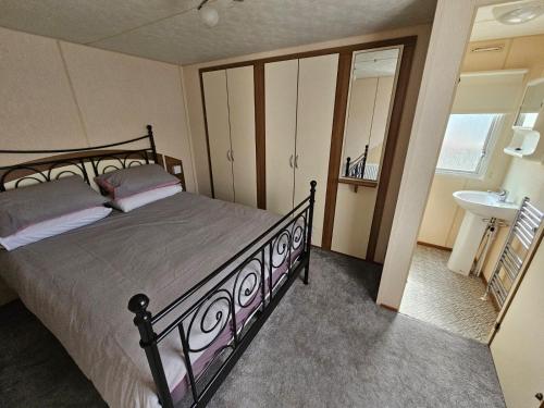 1 dormitorio con 1 cama y lavamanos en una habitación en Golden sands, en Rhyl