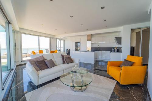 - un salon avec un canapé blanc et des fauteuils orange dans l'établissement Emplacement Rare avec Vue Mer Garage fermé, à Les Sables-dʼOlonne