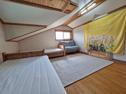 Habitación pequeña con cama y ventana en 나무집 게스트하우스 en Jeju