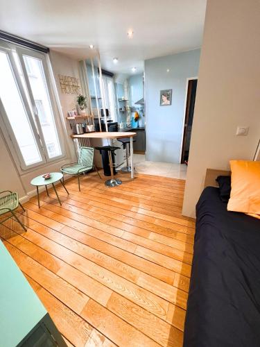 une chambre avec un lit et un parquet dans l'établissement Secret de Montreuil au Cœur de la Ville (Paris), à Montreuil