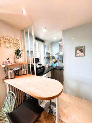 - une cuisine avec une table en bois dans une chambre dans l'établissement Secret de Montreuil au Cœur de la Ville (Paris), à Montreuil