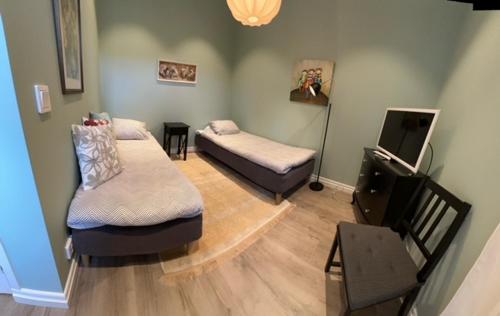 salon z 2 łóżkami i telewizorem w obiekcie Dalkärret w mieście Norrtälje