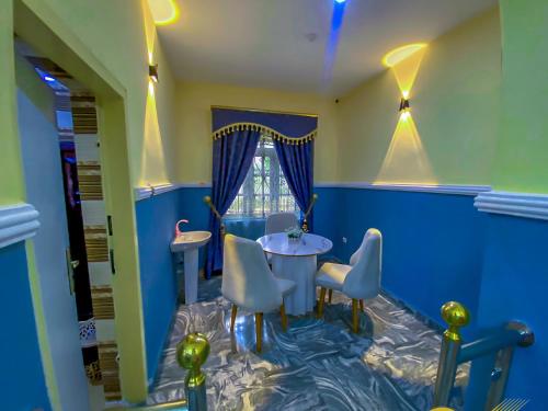 a blue room with a table and chairs at IMSMART Luxury Homes in Uyo