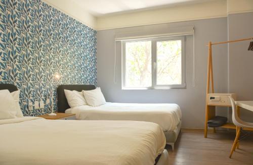 Casa Condesa Michoacan 113 في مدينة ميكسيكو: سريرين في غرفة ورق جدران أبيض وأزرق