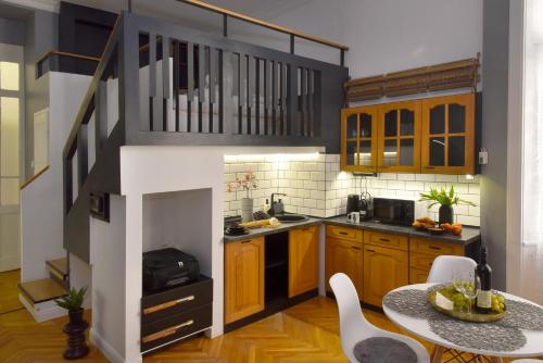 a small kitchen with wooden cabinets and a table at Walk Inn Váci 78 in Budapest
