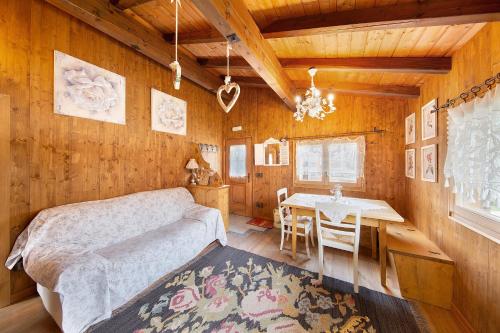 a living room with a bed and a dining room table at Orserose Chalet 8 I Fer Da Stir in Forno di Zoldo