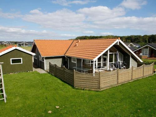 a house with an orange roof on a green yard at 8 person holiday home in Juelsminde in Sønderby