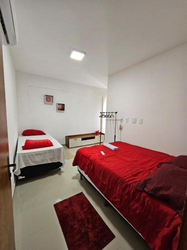 a bedroom with two beds and a red blanket at Vilagem tulum barra grande 2 quartos piscina in Marau