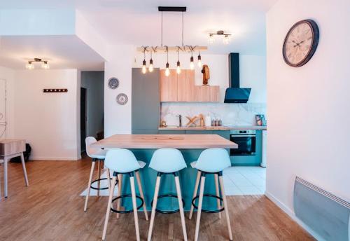 uma cozinha com uma mesa e alguns bancos azuis em Bourg La Reine Tranquil Haven em Bourg-la-Reine