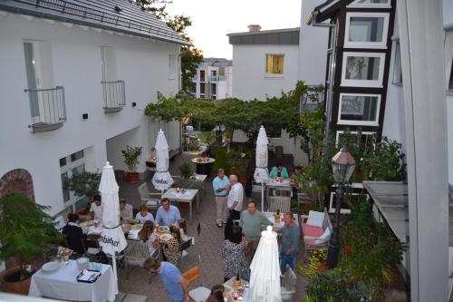 a group of people sitting at tables in a courtyard at Weinhaus Steppe Hotel 3***Superior und Weinstube in Waldbronn