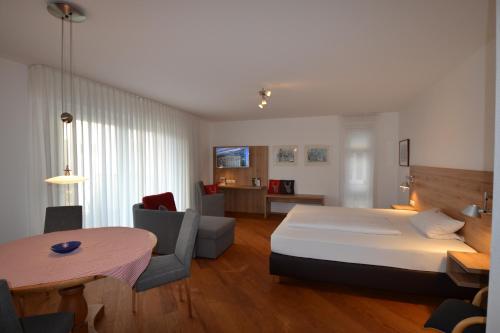um quarto com uma cama e uma mesa num quarto em Weinhaus Steppe Hotel 3***Superior und Weinstube em Waldbronn