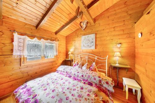 a bedroom with a bed in a wooden cabin at Orserose Chalet 5 I Fus in Forno di Zoldo