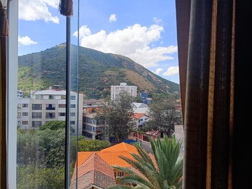 aus dem Fenster einer Stadt mit Bergblick in der Unterkunft Departamento bien ubicado con 2 habitaciones con camas dobles in Cochabamba