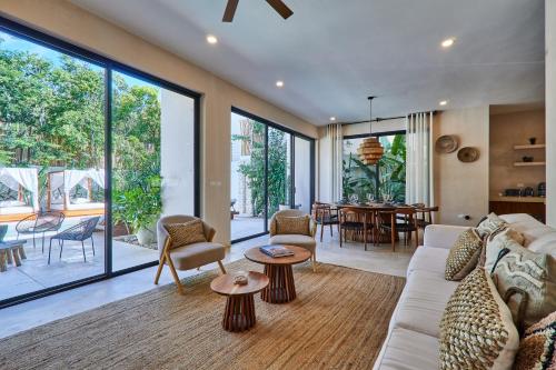 a living room with a couch and a table at Villa Sorella in Aldea Zama 24Hrs Security, 5min to the beach in Tulum