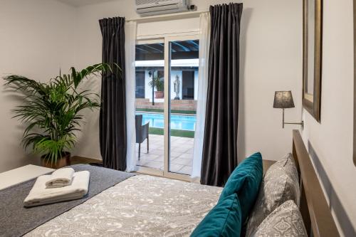 sypialnia z łóżkiem i widokiem na basen w obiekcie Villa Dora Bella Lanzarote w mieście Nazaret