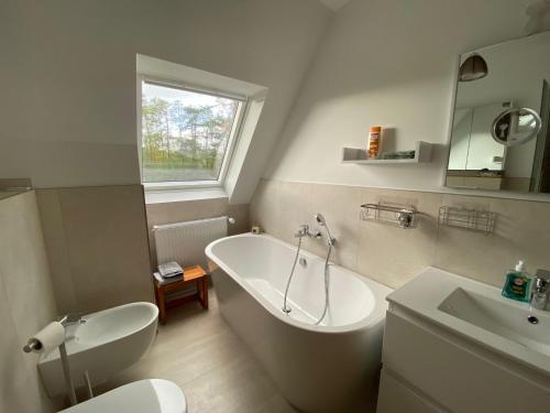 La salle de bains est pourvue d'une baignoire, de toilettes et d'un lavabo. dans l'établissement Ferienwohnung Hohenheide, à Warendorf