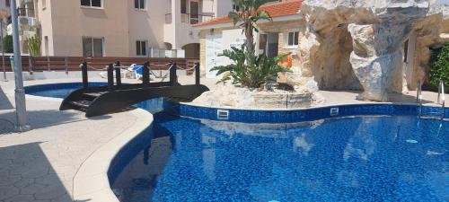 a swimming pool with a slide in a resort at Pyla Palms A1 204 in Pyla